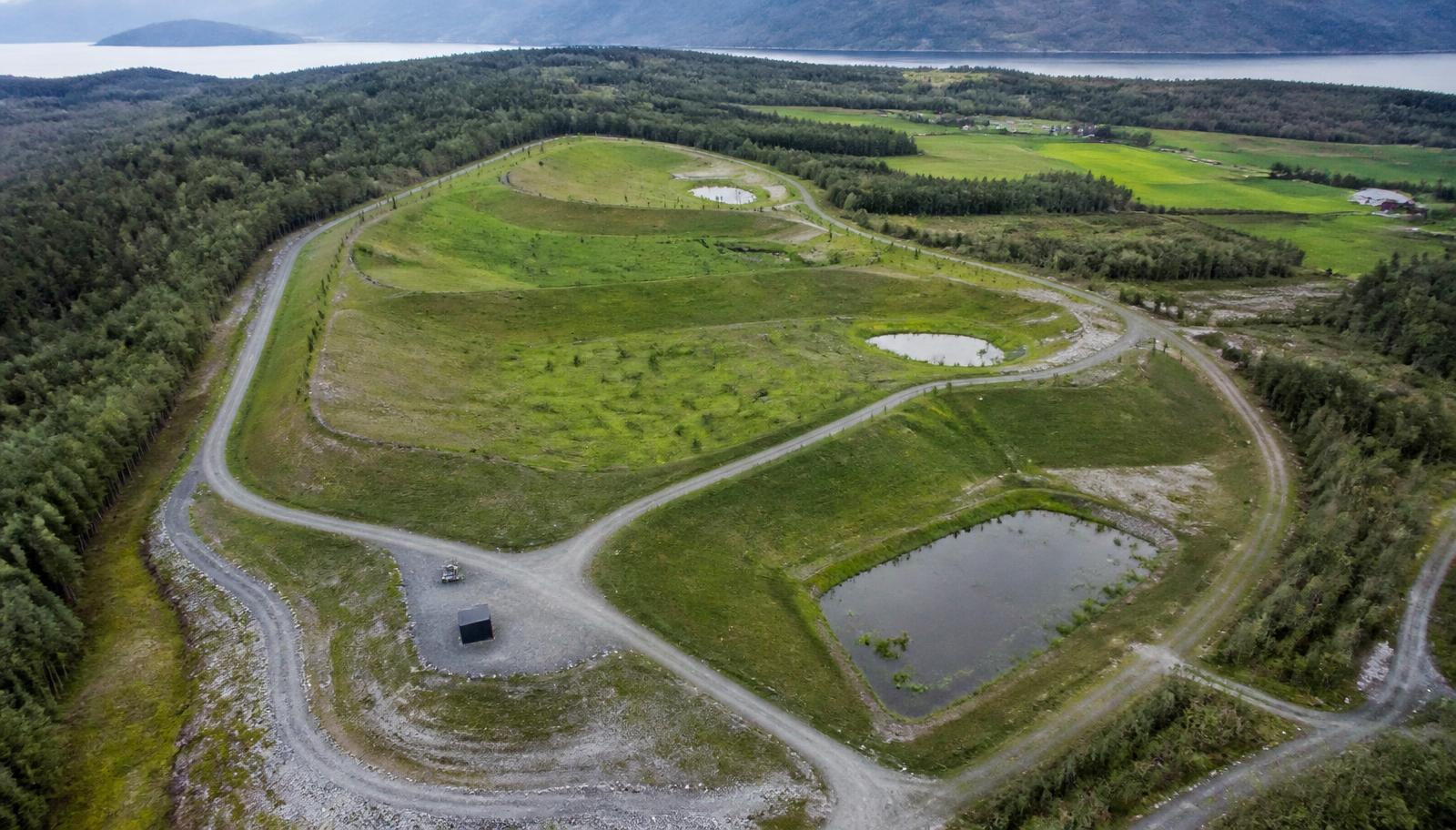 Luftfoto av et ferdig istandsatt deponiområde med grønn vegetasjon